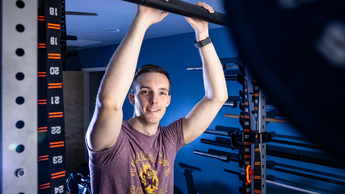 Man posing for photo in home gym